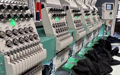 Machine à broder multi-têtes en train de broder des vêtements
